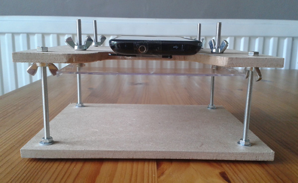 Front-view of the stand. You can see how the viewing platform (DVD case) is raised and lowered by the four bolts.